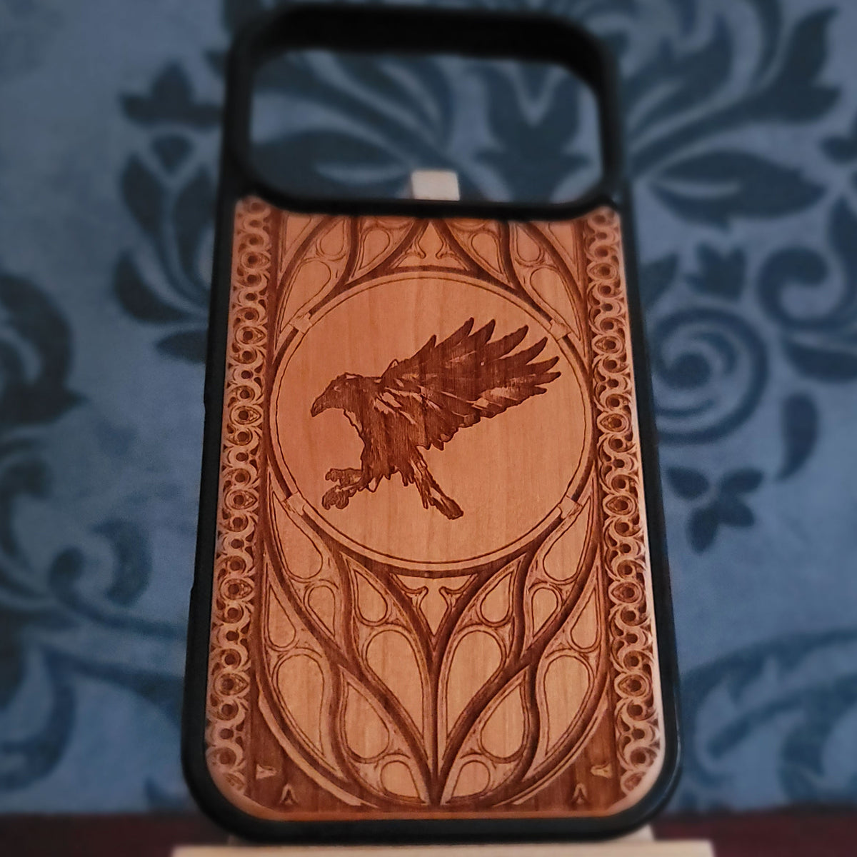 Black raven engraved wooden phone case with medieval inspired decorative border