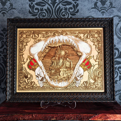 Large shark jaw and sailing ship wood wall art, dark brown ornate frame displayed around the nautical artwork