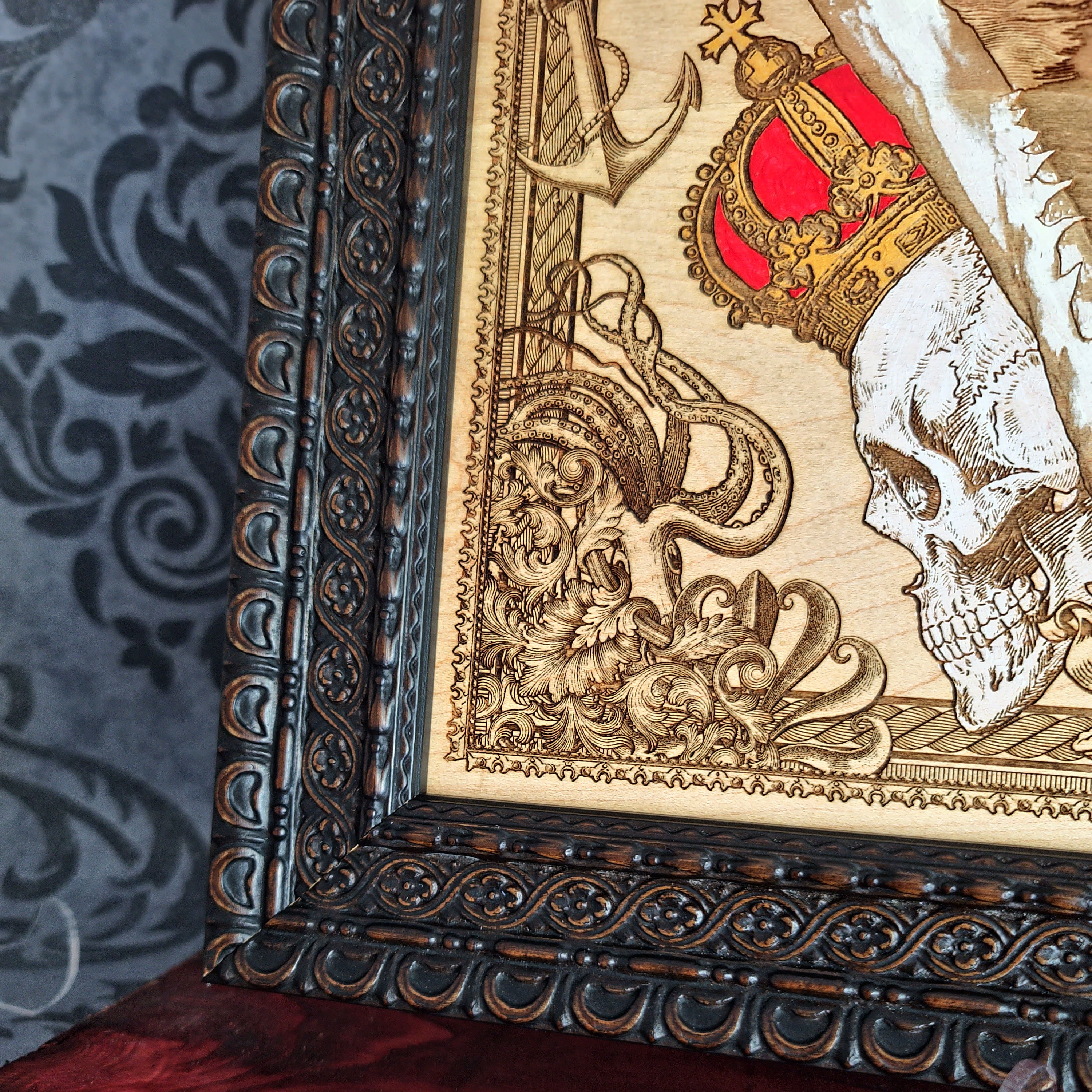 Large shark jaw and sailing ship wood wall art, close-up of the dark brown frame and engraved border