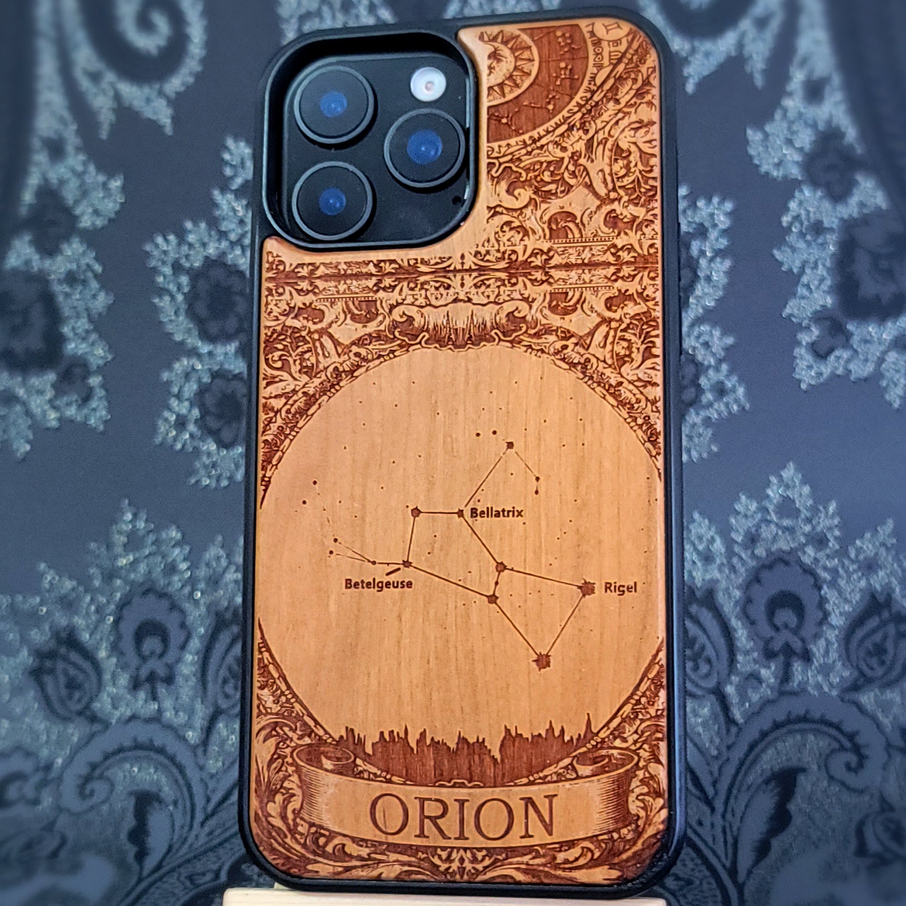 laser engraved wooden phone case featuring the Orion constellation with celestial star details on natural wood for iPhone and Samsung Galaxy models.