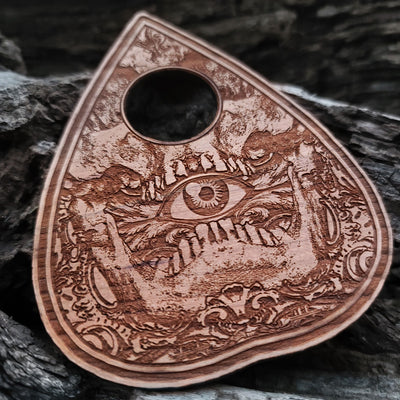 Mysterious wooden spirit board with engraved supernatural symbols.