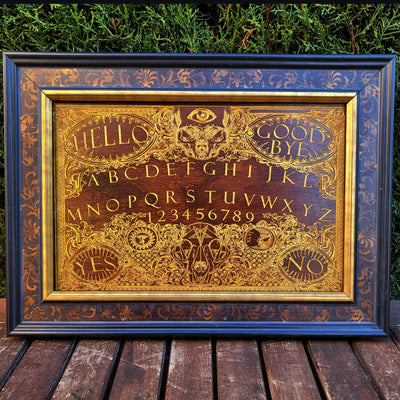 Mystic Ouija tablet wood engraving, featuring gold lettering and moon details.