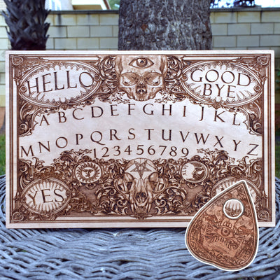 Hand-painted wooden Ouija board with gothic occult artwork.