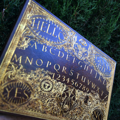 Stained wooden Ouija board wall decor with engraved numbers and alphabet.