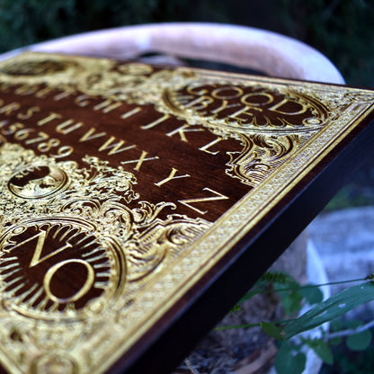 Witchcraft-style Ouija wall plaque with gold-filled details on rustic wood.