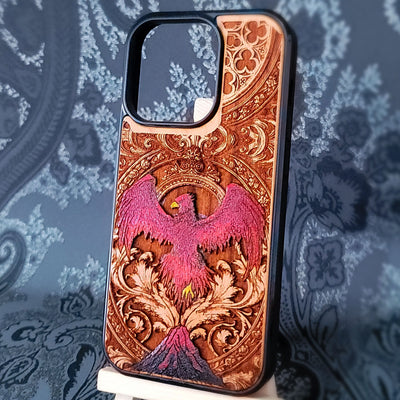 Deep laser engraved wooden phone case featuring a mythical phoenix bird with detailed flames and wings on natural wood for iPhone and Samsung Galaxy models.