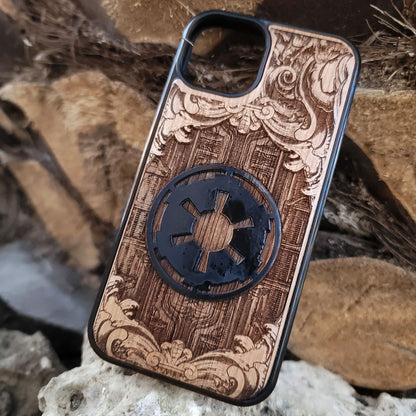 Wooden phone case with a detailed engraved sci-fi emblem resembling a galactic empire symbol, surrounded by ornate scrollwork, perfect for space opera fans