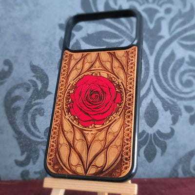 A wooden phone case with a carved red rose design, 