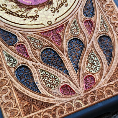 "Hand-painted wood phone case featuring the Eye of Sauron surrounded by intricate Elvish script and vibrant colored patterns. This laser-engraved and detailed design offers a unique blend of artistry and durability. Compatible with iPhone , 15, 14, 13, 12, 11, Pro Max, Mini, and Samsung Galaxy S, S24, S23, S22, S21, S20 Ultra, Plus, Note 20. Perfect for Lord of the Rings fans seeking a bold and protective accessory