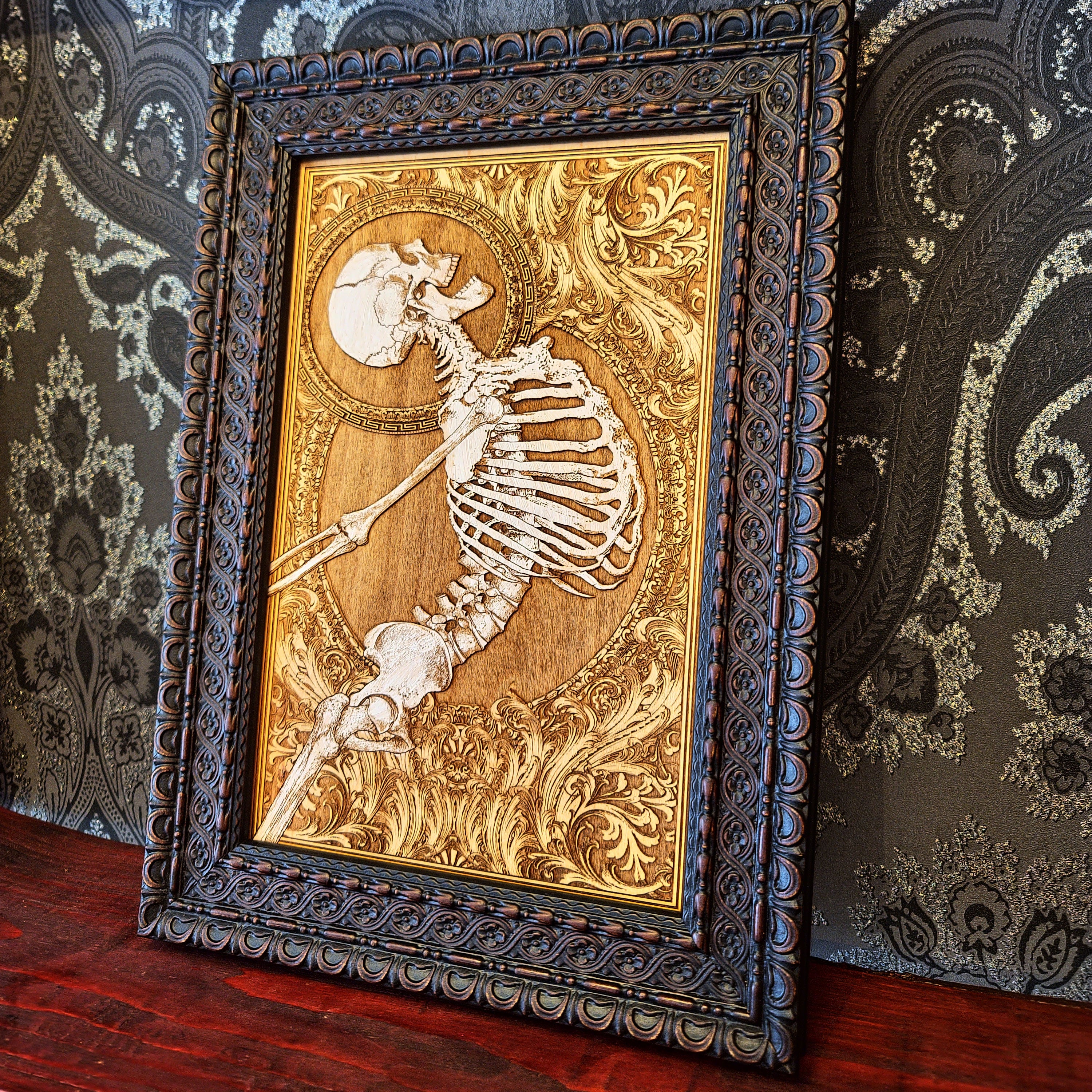 Decorative framed artwork with a skeleton design on a patterned wall background