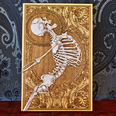 Decorative wooden plaque with a skeleton design on an ornate background