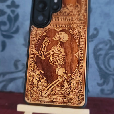 Praying skeleton wood phone case for iPhone and Samsung Galaxy, featuring gothic anatomical art with deep laser engraving.