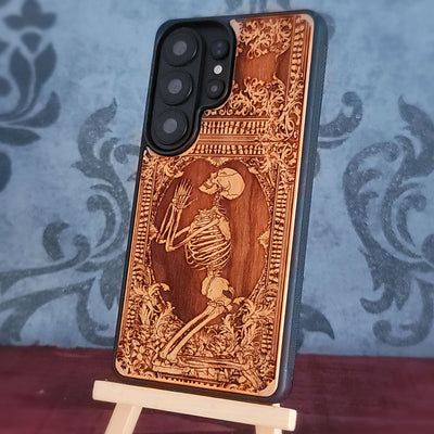Praying skeleton wood phone case for iPhone and Samsung Galaxy, featuring gothic anatomical art with deep laser engraving.