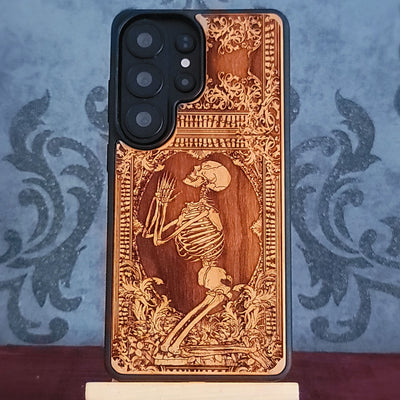 Praying skeleton wood phone case for iPhone and Samsung Galaxy, featuring gothic anatomical art with deep laser engraving.