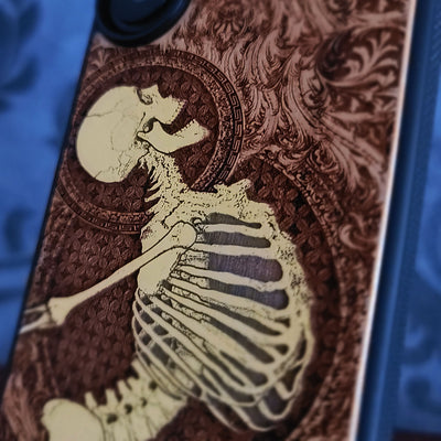 Cherry wood phone case with laser-engraved Gothic skeleton design for iPhone & Samsung Galaxy.