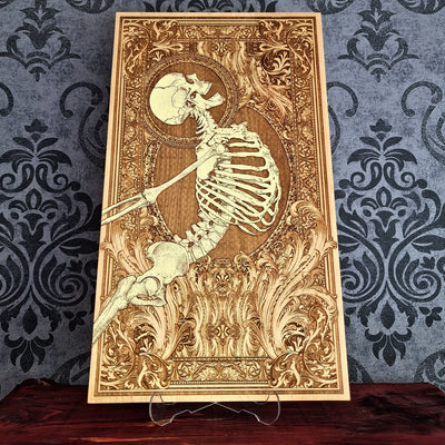 A rectangular wooden wall art plaque featuring a detailed laser-engraved skeleton , set against an ornate baroque-style border. 