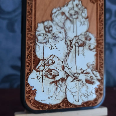 Hand-painted gothic wood phone case with stacked skulls and dripping details, compatible with iPhone and Galaxy, dark horror design.
