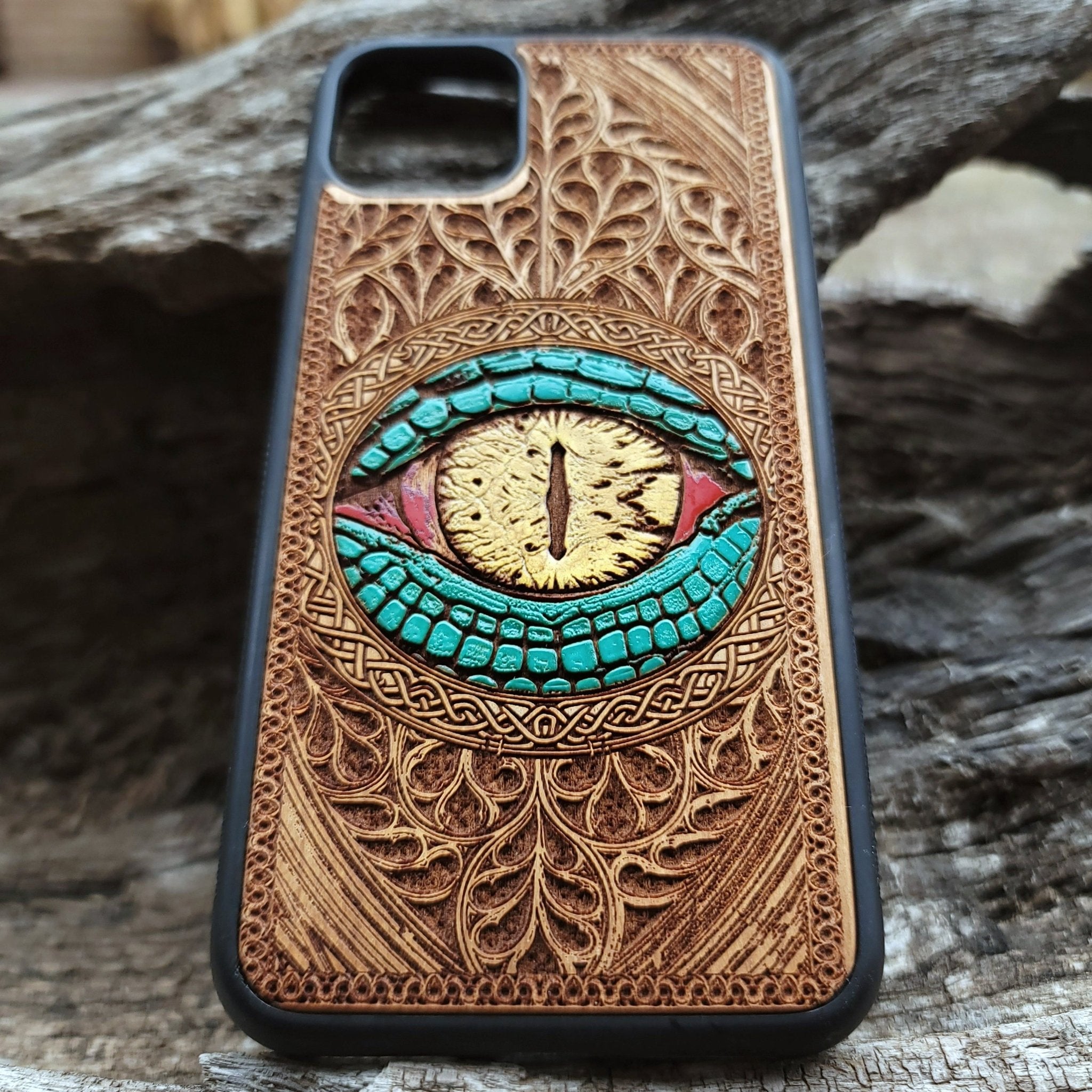 Close-up of intricate laser-engraved Snake Eye Gothic artwork on cherry wood phone case for iPhone & Samsung Galaxy