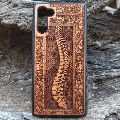 Wooden phone case with detailed skeleton spine carving, designed for iPhone , iPhone 15, Galaxy S, and other models. Perfect for lovers of gothic, anatomical art with premium protection.
