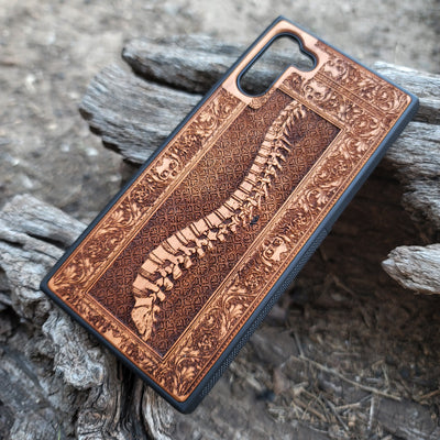 Wooden phone case with detailed skeleton spine carving, designed for iPhone , iPhone 15, Galaxy S, and other models. Perfect for lovers of gothic, anatomical art with premium protection.