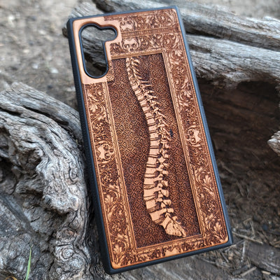 Wooden phone case with detailed skeleton spine carving, designed for iPhone , iPhone 15, Galaxy S, and other models. Perfect for lovers of gothic, anatomical art with premium protection.