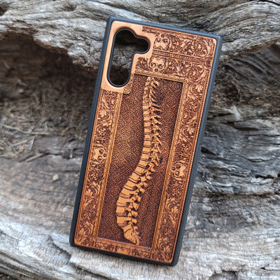 Wooden phone case with detailed skeleton spine carving, designed for iPhone , iPhone 15, Galaxy S, and other models. Perfect for lovers of gothic, anatomical art with premium protection.