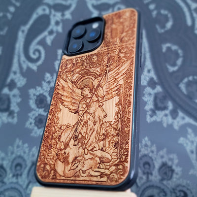 Deep laser engraved wooden phone case featuring Saint Michael Archangel fighting a demon with detailed religious artwork on natural wood for iPhone and Samsung Galaxy models.