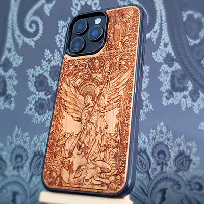 Deep laser engraved wooden phone case featuring Saint Michael Archangel fighting a demon with detailed religious artwork on natural wood for iPhone and Samsung Galaxy models.