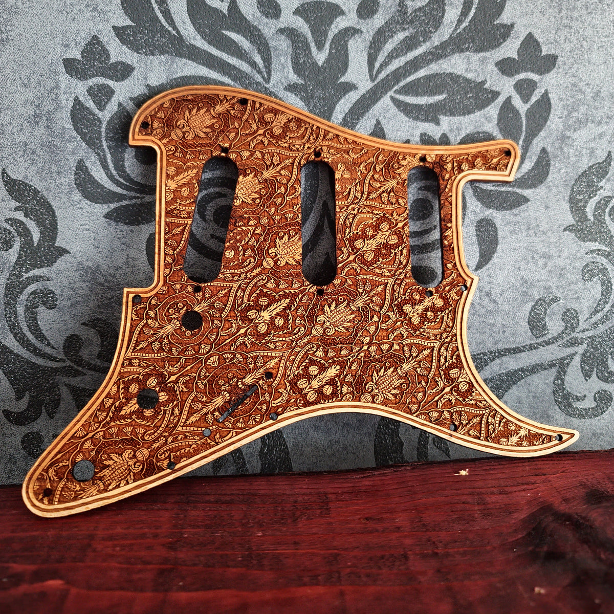 Real cherrywood Stratocaster pickguard with detailed decorative engraving