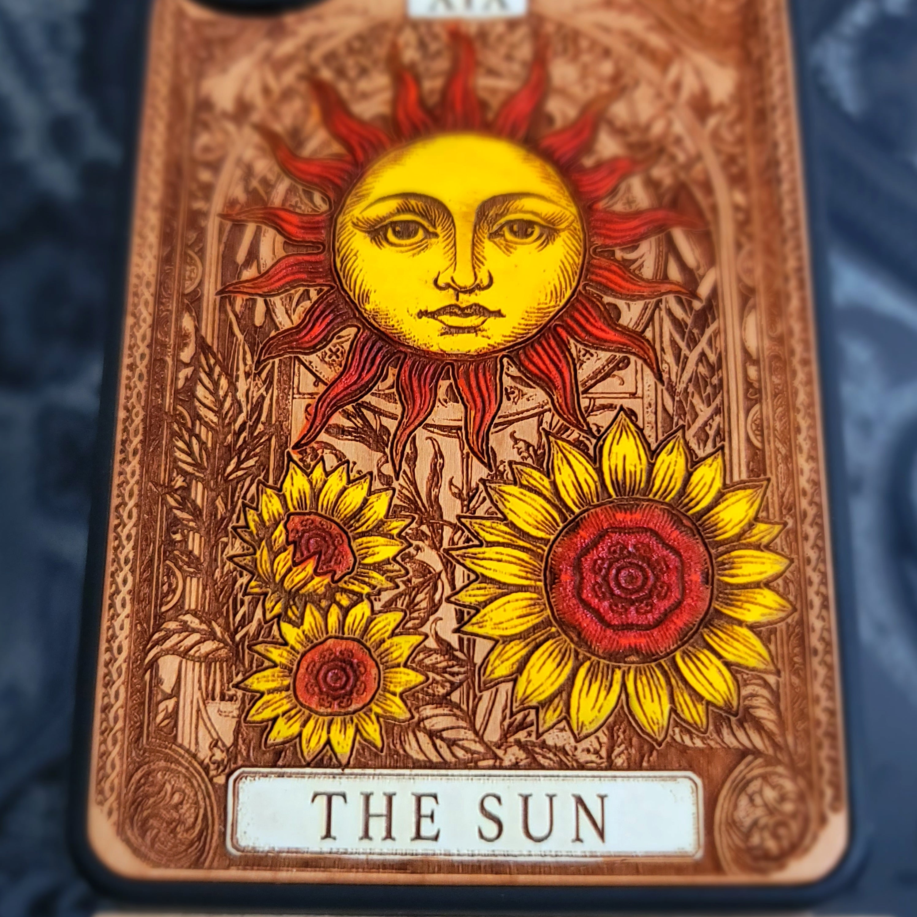 Deep laser engraved wooden phone case featuring The Sun tarot card with celestial mystical details on natural wood for iPhone and Samsung Galaxy models.