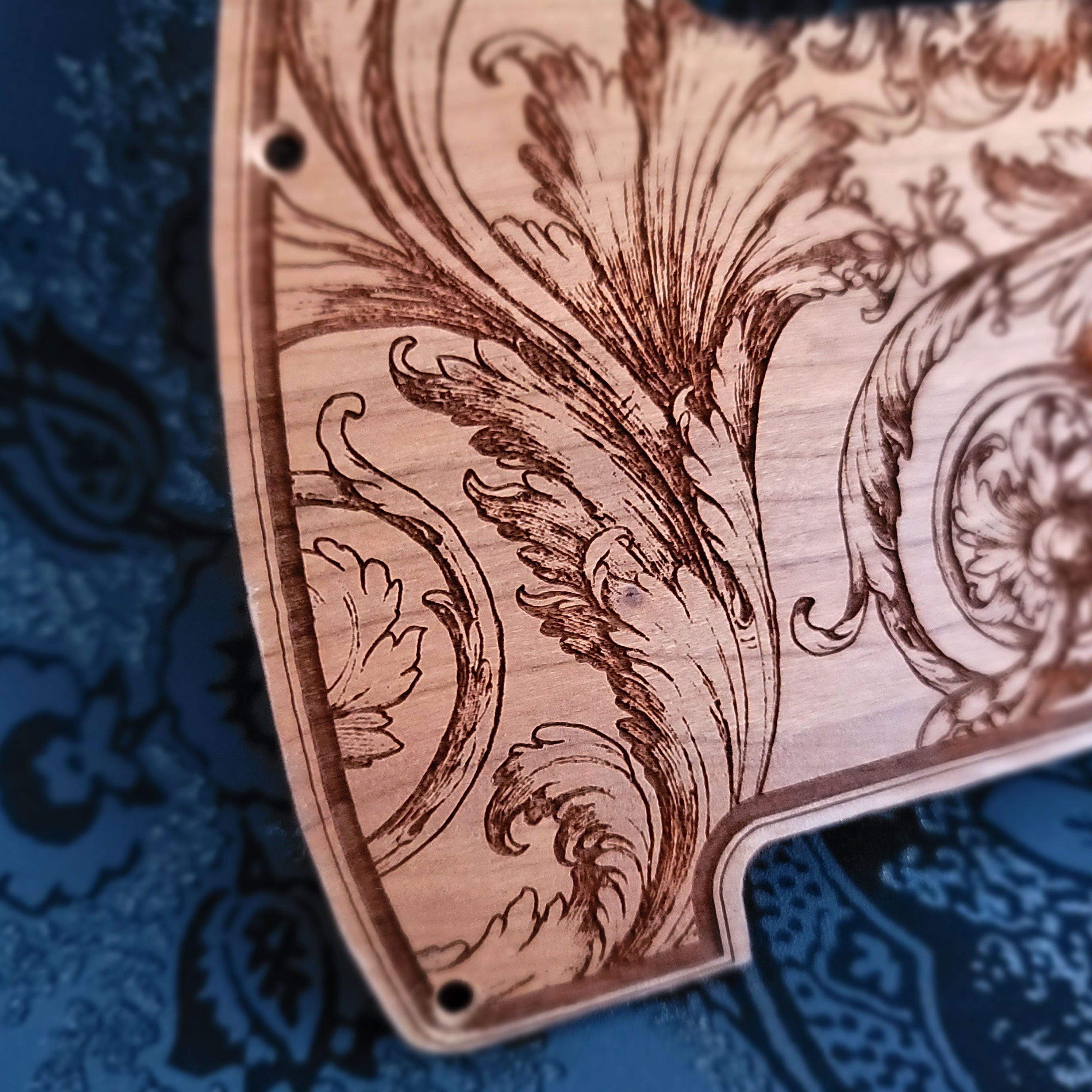 Floral wood pickguard for Telecaster electric guitar, laser-engraved design.