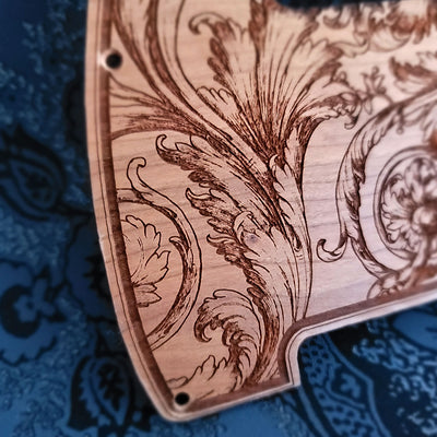 Floral wood pickguard for Telecaster electric guitar, laser-engraved design.