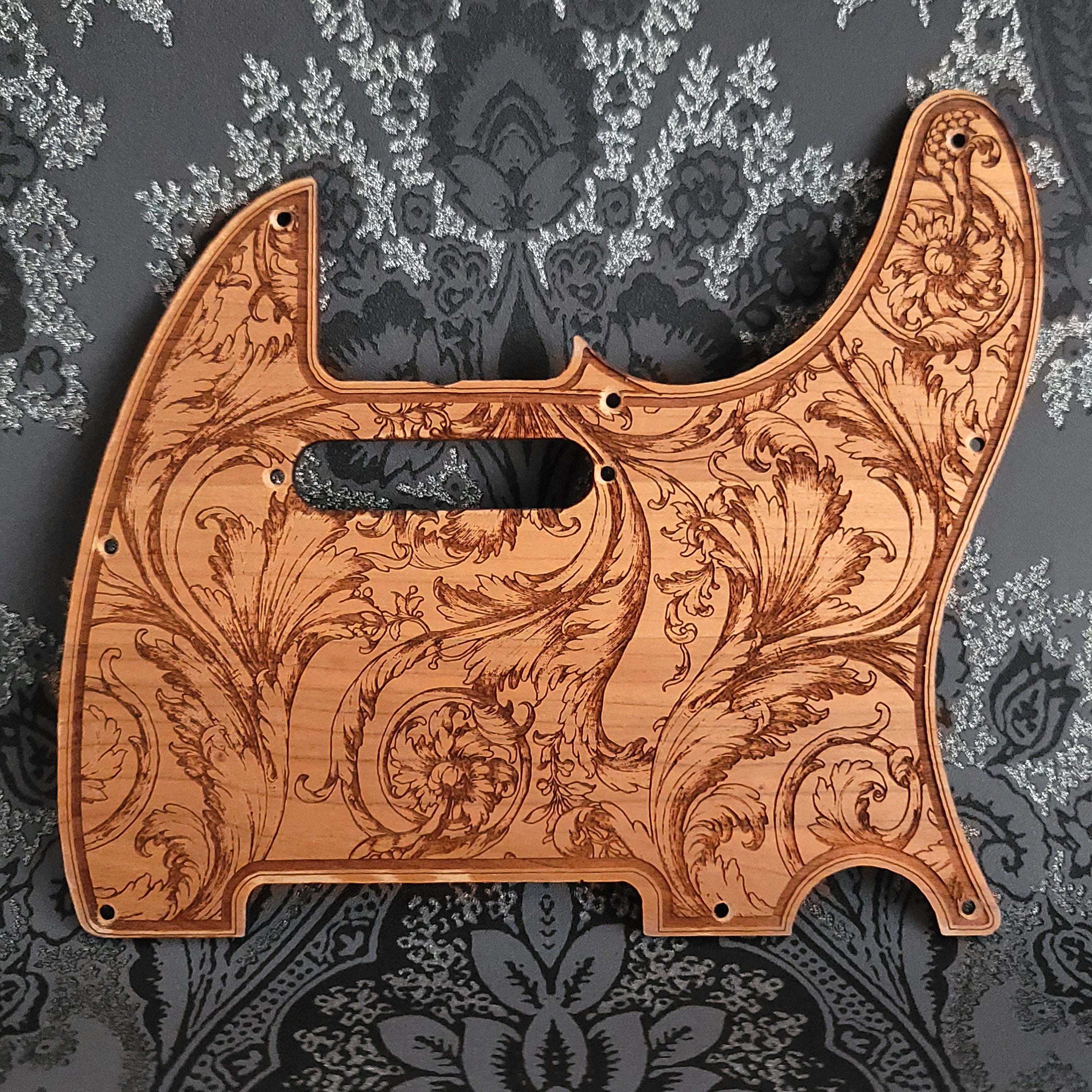 Floral wood pickguard for Telecaster electric guitar, laser-engraved design.