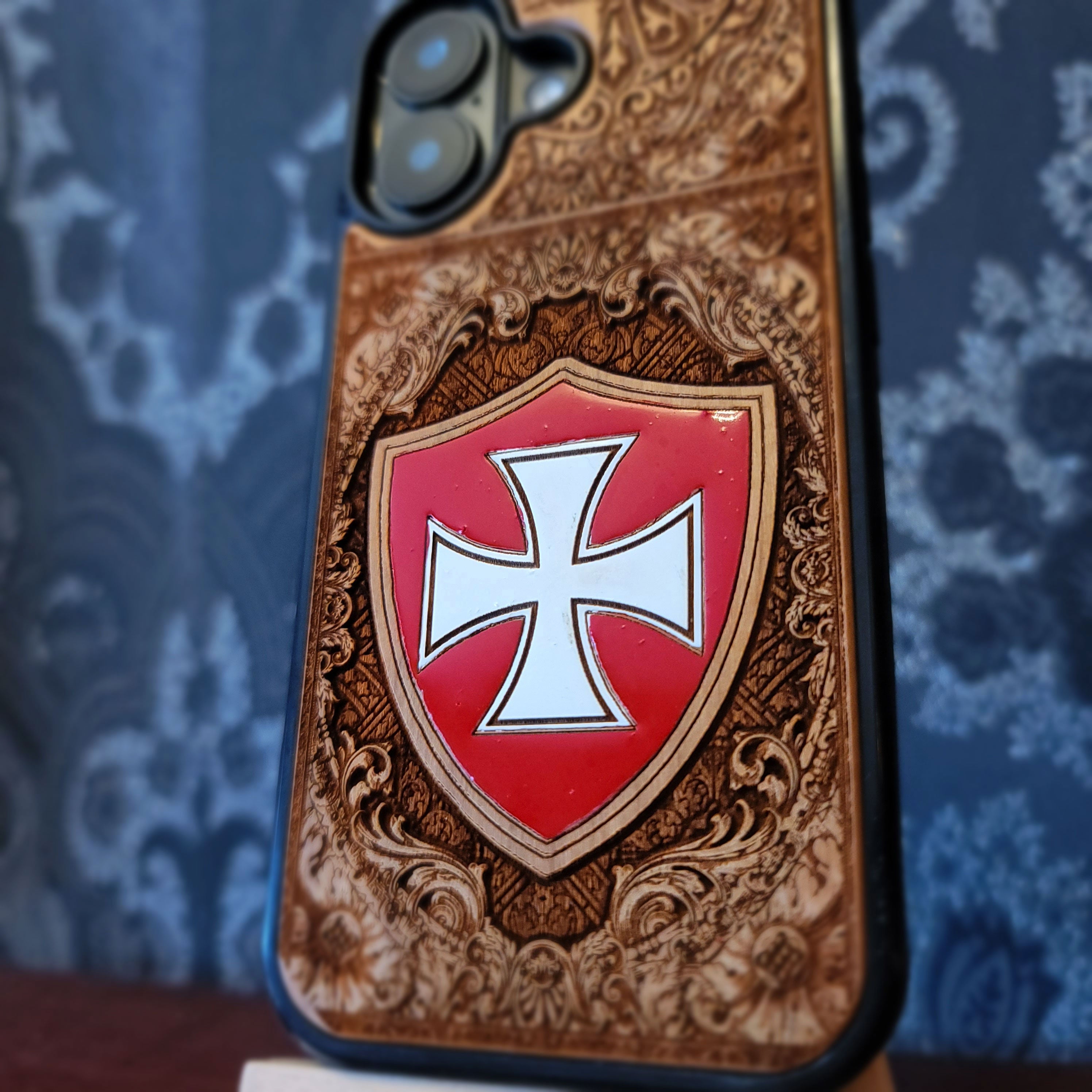 Deep laser engraved and hand painted wooden phone case featuring a medieval Templar cross design for iPhone and Samsung Galaxy models.