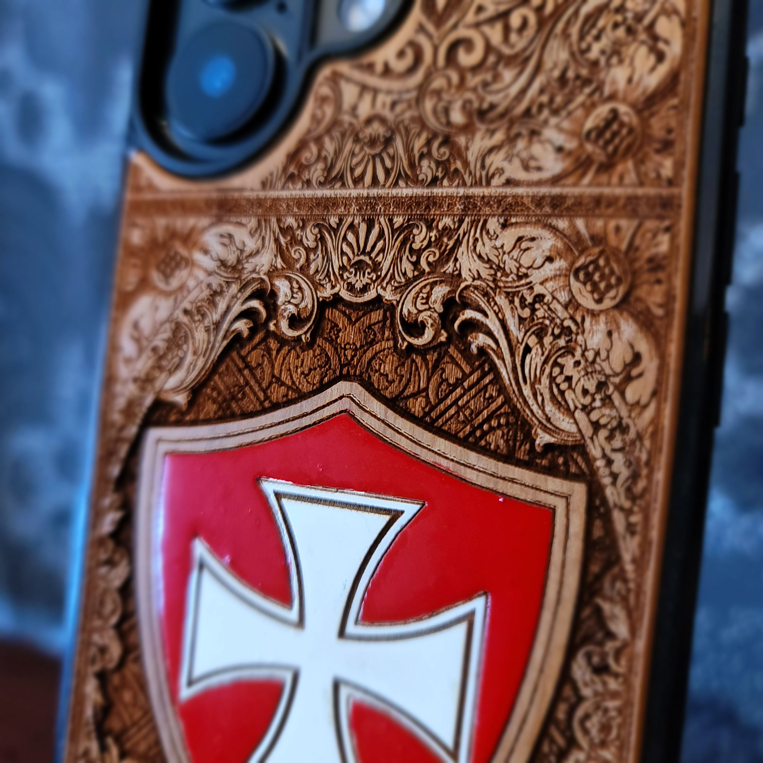 Deep laser engraved and hand painted wooden phone case featuring a medieval Templar cross design for iPhone and Samsung Galaxy models.