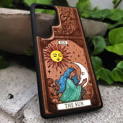 Phone case with 'The Sun' tarot card design featuring a sun and moon illustration.