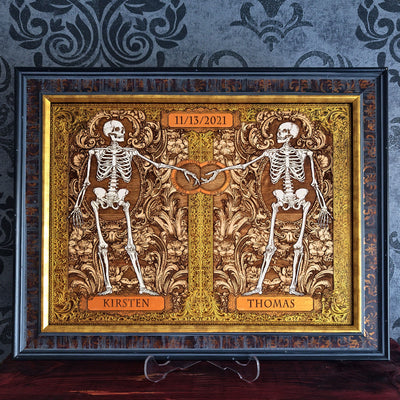 Gothic skeleton couple artwork with Amor Vincit Omnia Latin inscription