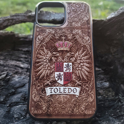 Detailed laser engraving of Toledo crest on cherry wood phone cover.
