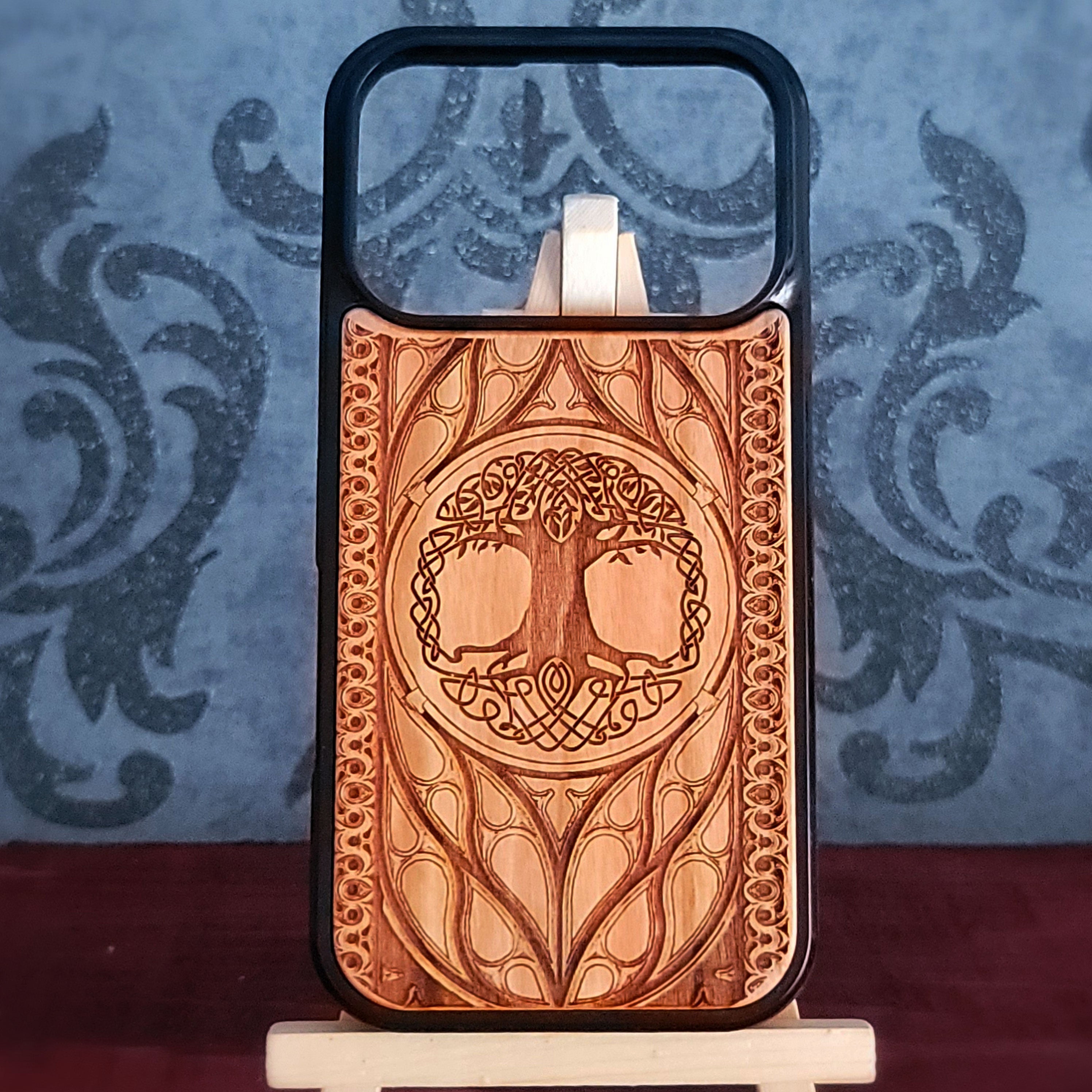 Wood phone case featuring a laser-engraved Tree of Life design surrounded by intricate Celtic-inspired patterns.