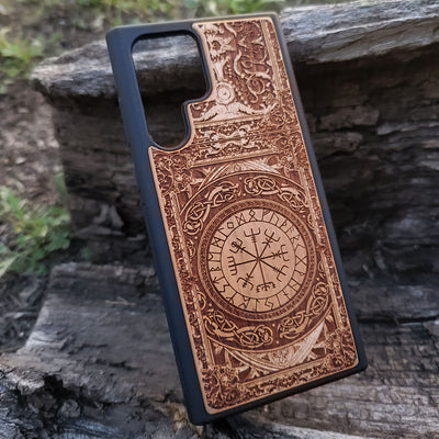 Viking-inspired wood phone case featuring the Vegvisir symbol surrounded by intricate Norse patterns and detailed engravings. Laser-engraved for durability and a unique design, this case is compatible with iPhone , 15, 14, 13, 12, 11, Pro Max, Mini, and Samsung Galaxy S, S24, S23, S22, S21, S20 Ultra, Plus, Note 20. A perfect protective accessory for fans of Norse mythology and Viking culture.