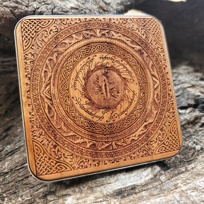 Close-up of the Eye of Sauron symbol on dark wood charger.