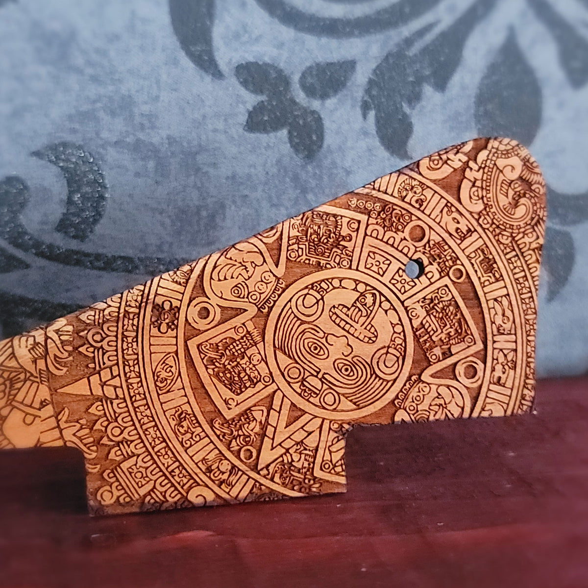 Close up of Aztec calendar artwork engraved into real cherry wood guitar pickguard