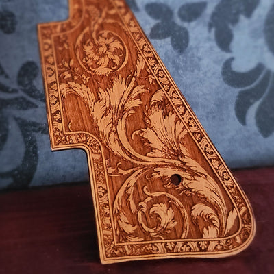 Close up of vintage flourish design engraved into natural cherry wood guitar pickguard