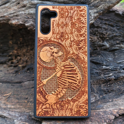 Cherry wood phone case with laser-engraved human skeleton and gold Gothic design for iPhone & Samsung Galaxy.