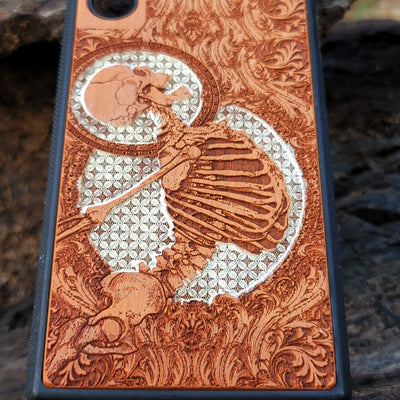 Gothic human skull with intricate details engraved on a wooden phone case, compatible with iPhone  and Samsung Galaxy S.