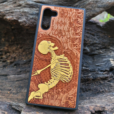 Side view of cherry wood phone case showcasing laser-engraved Gothic skeleton pattern for iPhone & Samsung Galaxy.