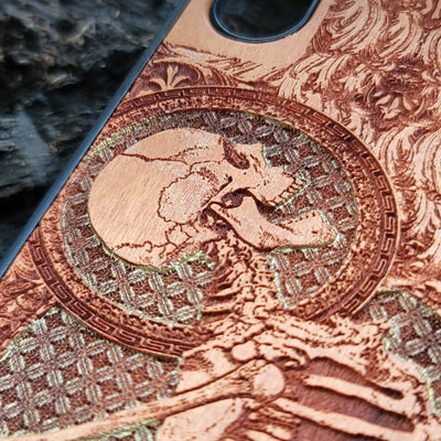 Hand-painted cherry wood phone case with intricate laser engraving of human skeleton and Gothic artwork.