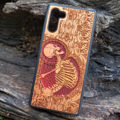 Hand-painted cherry wood phone case with Gothic skeleton engraving, designed for iPhone & Samsung Galaxy models.