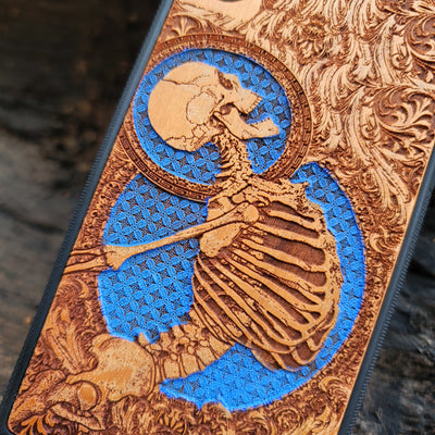 Hand-finished cherry wood phone case with intricate laser-engraved Gothic skeleton art for iPhone & Samsung Galaxy.