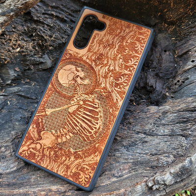 Hand-painted cherry wood phone case with intricate laser engraving of human skeleton and Gothic artwork.